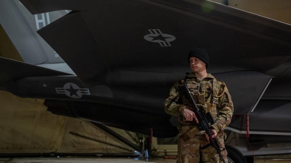 Airman 1st Class Matthew J. Brown, a 52nd Security Forces Squadron patrolman at5 Spangdahlem Air Base, Germany, watches over a U.S. Air Force F-35 Lightning II aircraft at Siauliai Air Base, Lithuania, Feb. 26, 2022. (Senior Airman John R. Wright/Air Force)