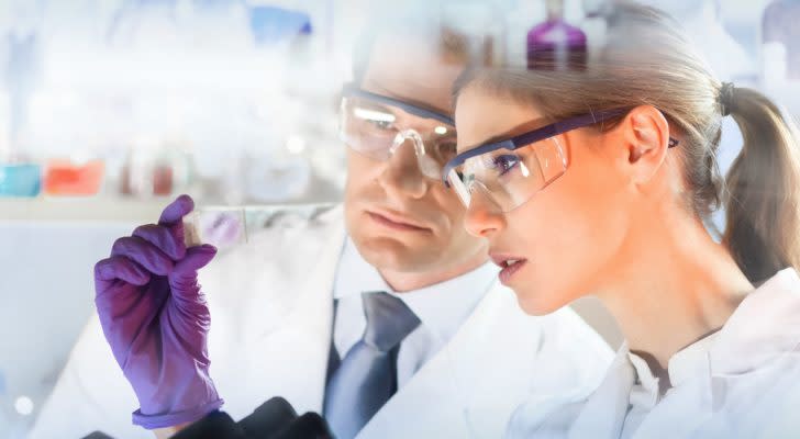 Image of two scientists in lab coats studying results in a lab