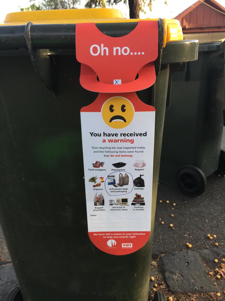 recycling bin warning with frowning face attached to bin in Moreland, Melbourne