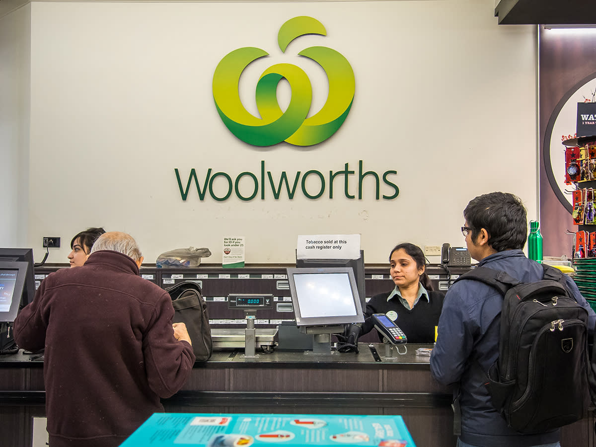 Customers and staff member at Woolworths service desk