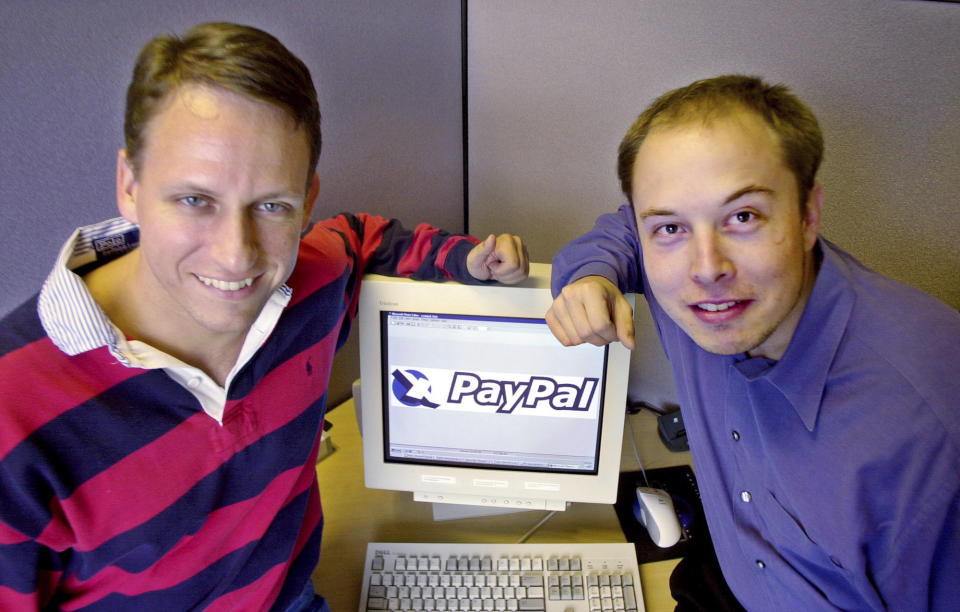 FILE - PayPal Chief Executive Officer Peter Thiel, left, and founder Elon Musk, right, pose with the PayPal logo at corporate headquarters in Palo Alto, Calif., Oct. 20, 2000. Musk may want to send “tweet” back to the birds, but the ubiquitous term for posting on the site he now calls X is here to stay, at least for now. For one, the word is still plastered all over the website formerly known as Twitter. Write a post, you still need to press a blue button that says “tweet” to publish it. To repost it, you still tap “retweet.” (AP Photo/Paul Sakuma, File)