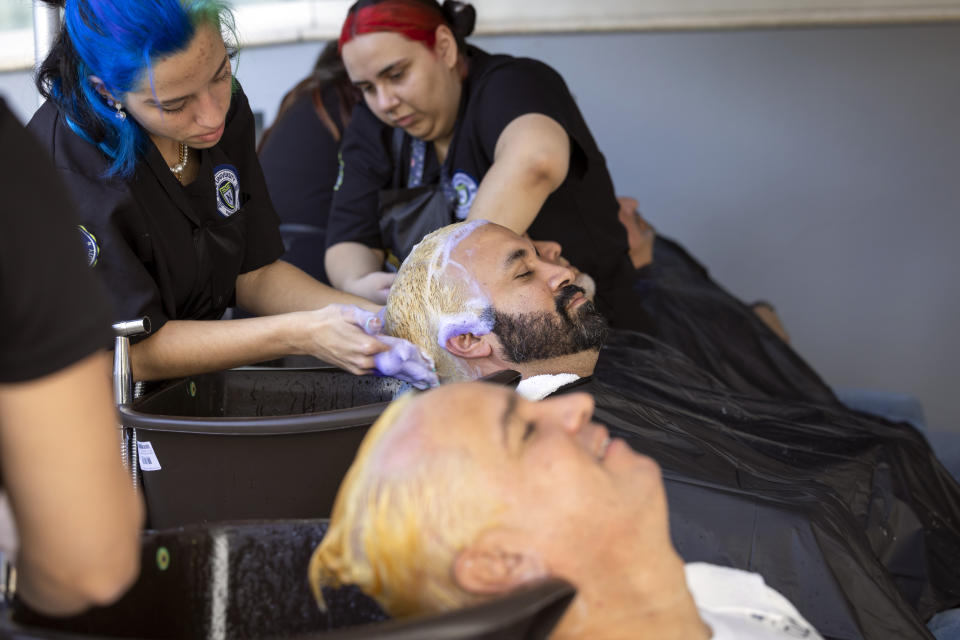 Fans of the Puerto Rico baseball team get their hair bleached as part of a mass hair dying event in an attempt to break the Guinness World Record for the most hair dyed in eight hours in Guaynabo, Puerto Rico, Friday, March 10, 2023. Going blond, which began as a joke among team members playing in California many years ago, was set up by fans to show support for their team competing at the World Baseball Classic. (AP Photo/Alejandro Granadillo)