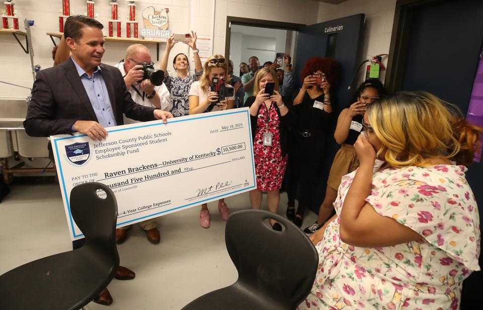 Raven Brackens, a student at Moore High School, receives a $10,500 scholarship check from superintendent Marty Pollio.  The money comes from the Jefferson County Public Schools Employee Sponsored Student Scholarship Fund.  $70,000 was awarded on Friday, May 19, 2023, to students at six JCPS high schools.