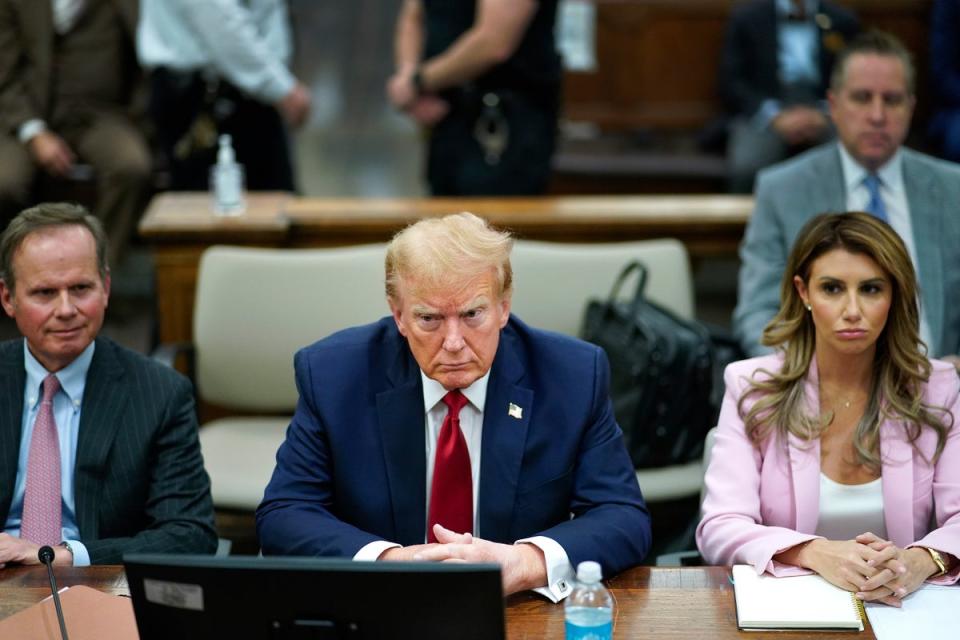 Donald Trump sits with his attorneys Chris Kise, left, and Alina Habba, right, during a civil fraud trial in New York on  7 December. (AP)