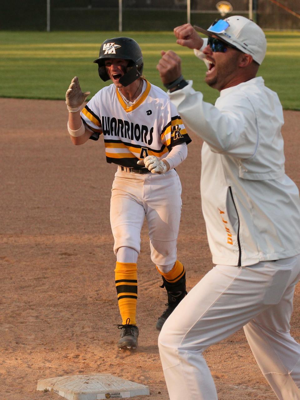 Watkins Memorial's Aydan Guthrie and first base coach Jake Duffy celebrate his game-winning hit against Olentangy on Wednesday.