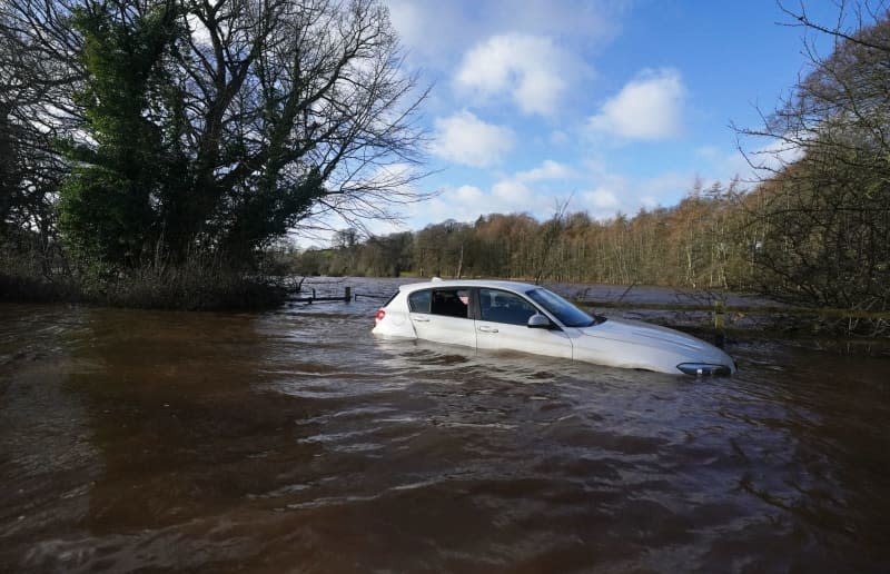 A car stranded in flood water on Warwick bridge in Cumbria. Thousands of people have been left without power as Storm Isha brought disruption to the electricity and transport networks across the UK. Owen Humphreys/PA Wire/dpa