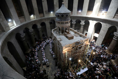 FILE PHOTO: Christian worshippers surround the Edicule as they take part in a Sunday Easter mass procession in the Church of the Holy Sepulchre in Jerusalem's Old City April 16, 2017. REUTERS/Ammar Awad/File Photo