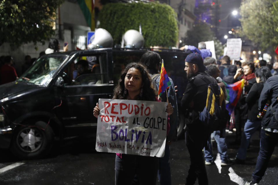 A woman holds a sign that reads in Spanish "Disavowal of the coup in Bolivia. Yankees and OAS out," as Bolivians in Mexico and supporters of former President Evo Morales protest in front of the Bolivian embassy in Mexico City, Monday, Nov. 11, 2019. Mexican Foreign Secretary Marcelo Ebrard announced that Mexico had granted an asylum request from Morales, whose whereabouts remained unknown. (AP Photo / Eduardo Verdugo)