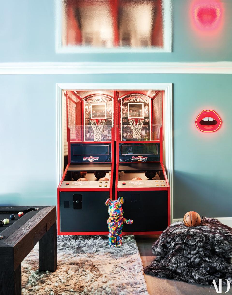 A candy-print Be@rbrick collectible toy stands in front of a Super Shot game machine. Neon light by Studio Job and Seletti.