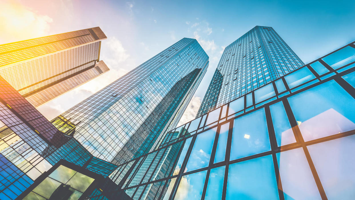 Bottom view of modern skyscrapers in business district in beautiful evening light at sunset with monochrome retro vintage Instagram style filter and lens flare effect.