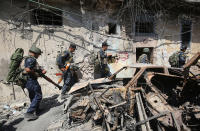 <p>Iraqi forces walk past charred vehicles as they advance through the Old City of Mosul on June 24, 2017 during the ongoing offensive to retake the last district held by the Islamic State (IS) group. (Photo: Ahmad al-Rubaye/AFP/Getty Images) </p>