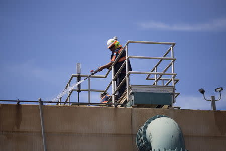 Workers maintain the Edward C. Little Water Recycling Facility during the West Basin Municipal Water District's tour of a water recycling facility in El Segundo, California July 11, 2015. REUTERS/David McNew