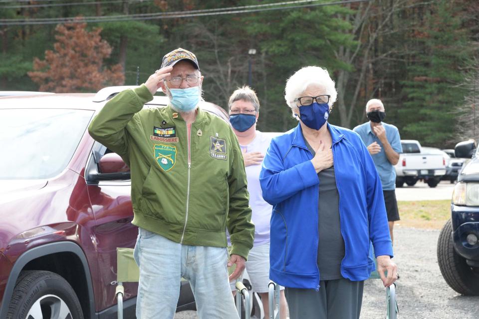 Bill LaBossiere and wife Linda LaBossiere salute during an outdoor concert on Veterans Day at the Bridgewater Council on Aging, Wednesday, Nov. 11, 2020.