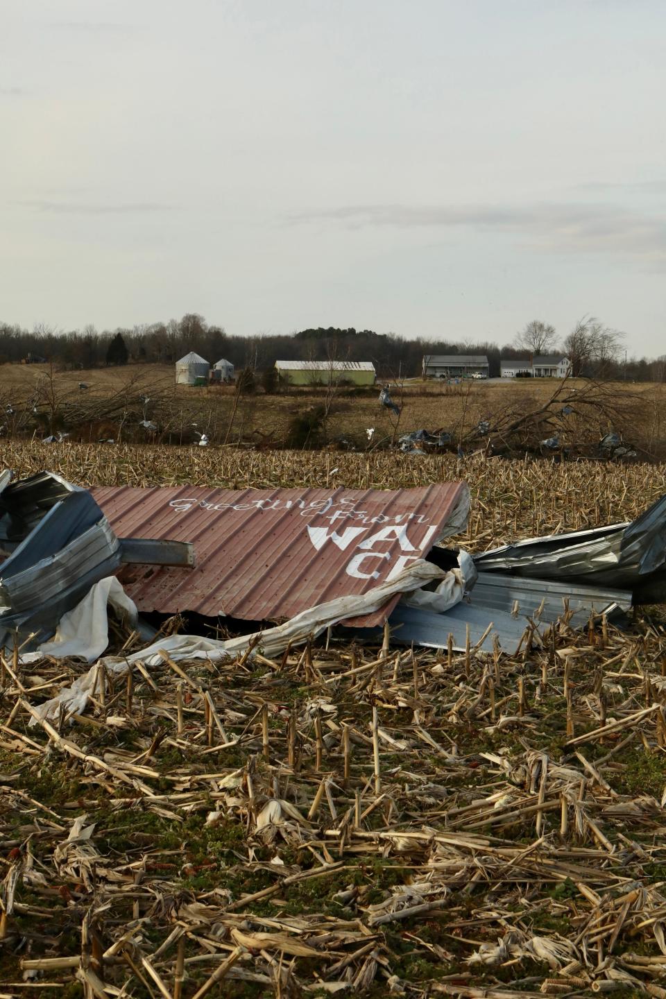 Half of a sign that reads, "Greetings from Walton Creek" lies in a field near Centertown, Ky., after a tornado passed through in early December. The other half of the sign was found a mile away. The message adorned a garage owned by Ben Ashby, whose insurance will only partially cover $128,000 in damage to several buildings on his property.