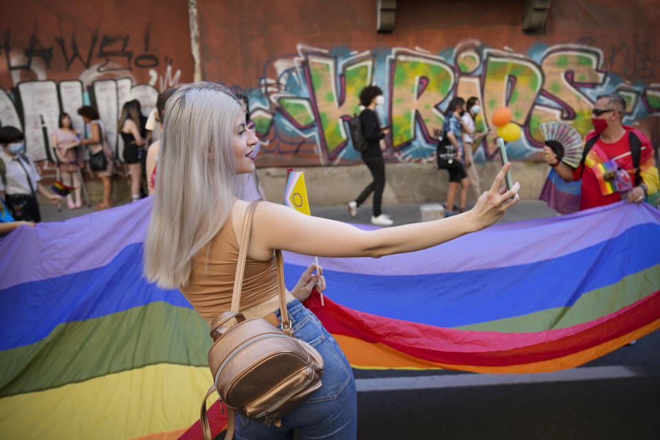 A young woman shoots a selfie picture during the Bucharest Pride 2021 in Bucharest, Romania, Saturday, Aug. 14, 2021. The 20th anniversary of the abolishment of Article 200, which authorized prison sentences of up to five years for same-sex relations, was one cause for celebration during the gay pride parade and festival held in Romania's capital this month. People danced, waved rainbow flags and watched performances at Bucharest Pride 2021, an event that would have been unimaginable a generation earlier. (AP Photo/Vadim Ghirda)