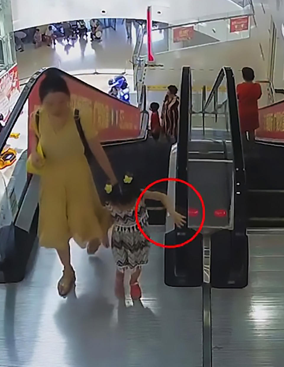 The five-year-old girl and her mother were in a shopping centre in China when the girls arm became stuck in the escalator. Source: AsiaWire/Australscope