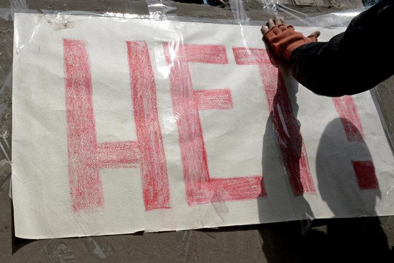 A pro-Russian activist displays a banner reading "No!" on a barricade outside the police regional building seized by pro-Russia activists in the eastern Ukrainian city of Slavyansk, on April 19, 2014