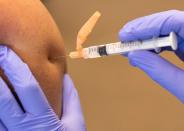 FILE PHOTO: A CalFire firefighter is administered his first dose of the Moderna vaccine in El Cajon, California