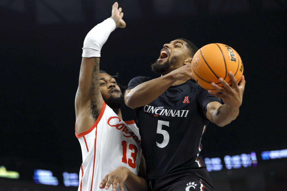 Cincinnati guard David DeJulius (5) goes to the basket as Houston forward J'Wan Roberts (13) defends during the second half of an NCAA college basketball game in the semifinals of the American Athletic Conference Tournament, Saturday, March 11, 2023, in Fort Worth, Texas. (AP Photo/Ron Jenkins)