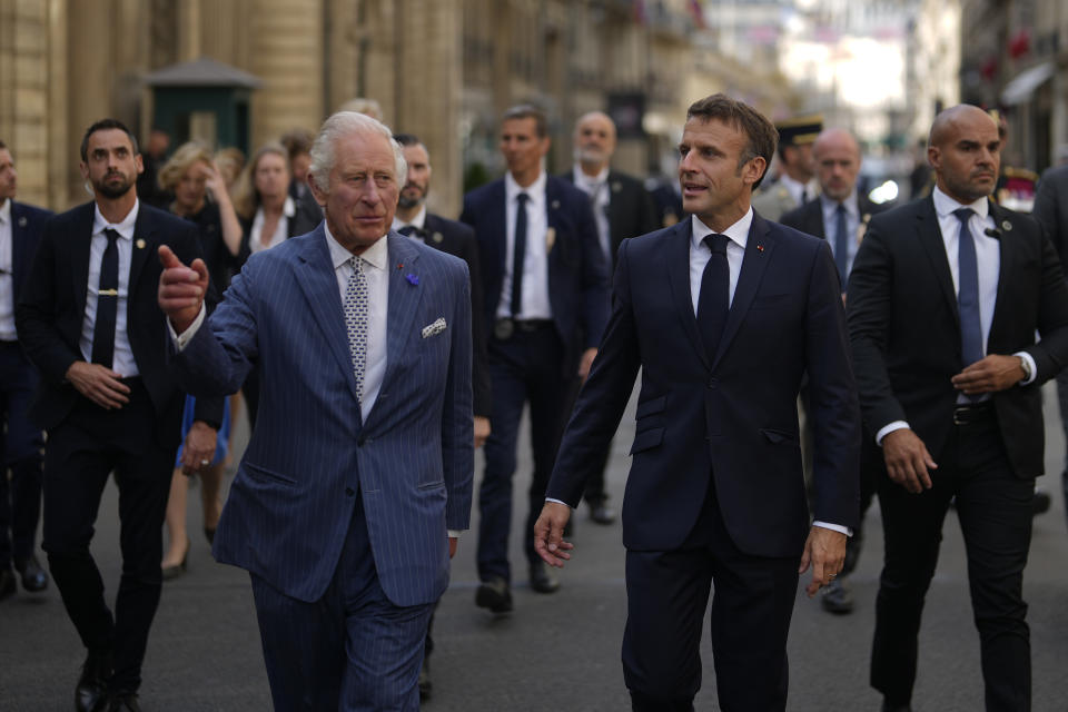 French President Emmanuel Macron, right, and Britain's King Charles III walk in the street from the Elysee Palace to the British ambassador to France's residence, Wednesday, Sept. 20, 2023 in Paris. King Charles III of the United Kingdom starts a three-day state visit to France on Wednesday meant to highlight the friendship between the two nations with great pomp, after the trip was postponed in March amid widespread demonstrations against President Emmanuel Macron's pension changes. (AP Photo/Thibault Camus, Pool)