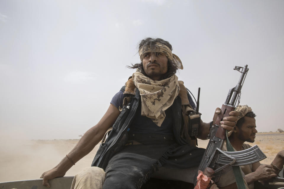 Yemeni fighters backed by the Saudi-led coalition ride on the back of an armored vehicle as they leave the front lines of Marib, Yemen, Saturday, June 19, 2021. (AP Photo/Nariman El-Mofty)