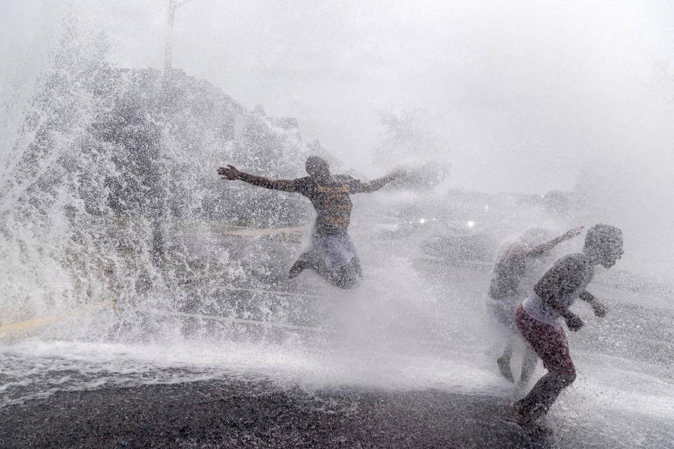 Children play in the spray of an open fire hydrant on a hot summer day in the Auburn Gresham neighborhood in Chicago, Wednesday, Aug. 26, 2020. As summer arrived, shootings surged in the 6th police district, which includes Auburn Gresham. Over three months, there were a shocking 175 victims. The youngest, 10 and 11, were wounded in a drive-by attack. (AP Photo/David Goldman)