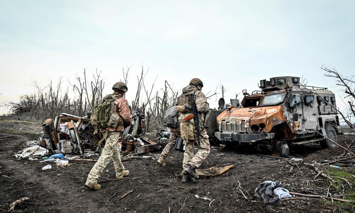 <span>Ukrainian soldiers walk among destroyed military equipment near Robotyne, Zaporizhzhia. The US will impose more than 500 fresh sanctions on Russia to mark the second anniversary of the war in Ukraine and following the death of Alexei Navalny.</span><span>Photograph: Ukrinform/REX/Shutterstock</span>