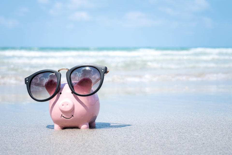 Cute piggy bank wearing sunglass on the beach.