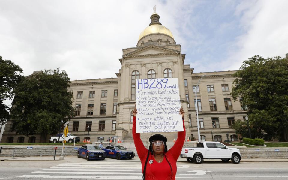 Demonstrators hold signs during a protest against House Bill 289 in front of the state capitol in Atlanta, Georgia - Shutterstock