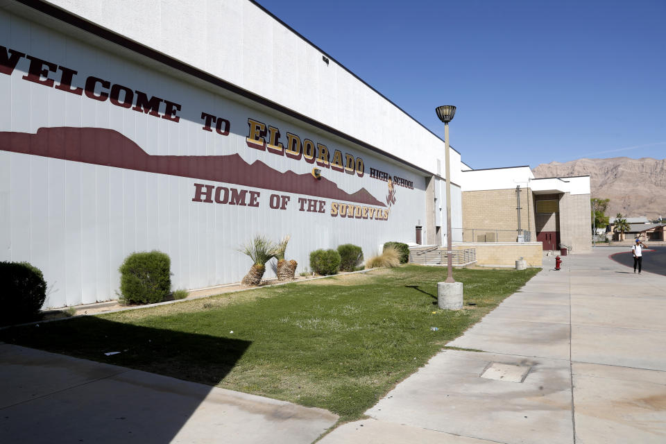 FILE - An unidentified person walks outside Eldorado High School in Las Vegas on April 8, 2022. A Las Vegas teenager has pleaded guilty as an adult to felony charges Wednesday, April 19, 2023, that a prosecutor says could get him decades in prison for attacking a high school teacher and leaving her unconscious in a classroom after school a year ago. (Steve Marcus/Las Vegas Sun via AP, File)