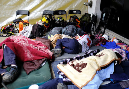 Members of rescue team and volunteers rest in front of a collapsed building, after an earthquake in Mexico City, Mexico September 26, 2017. REUTERS/Nacho Doce