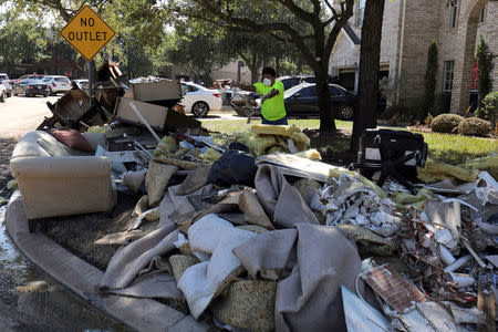 FILE PHOTO: The contents of a flooded home are moved to the street in the aftermath of tropical storm Harvey in Katy, Texas, U.S., September 8, 2017. REUTERS/Mike Blake/File Photo