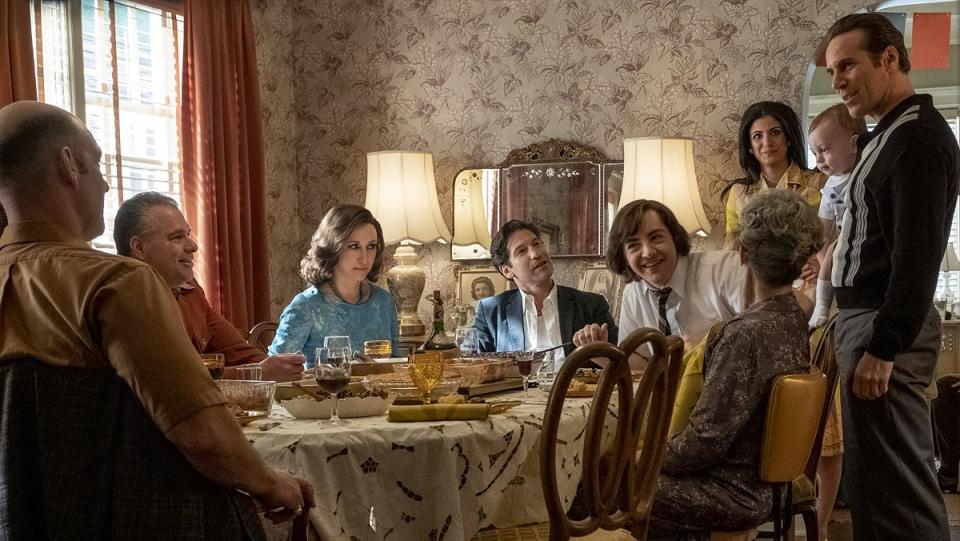 The cast of The Many Saints of Newark sits around a table.