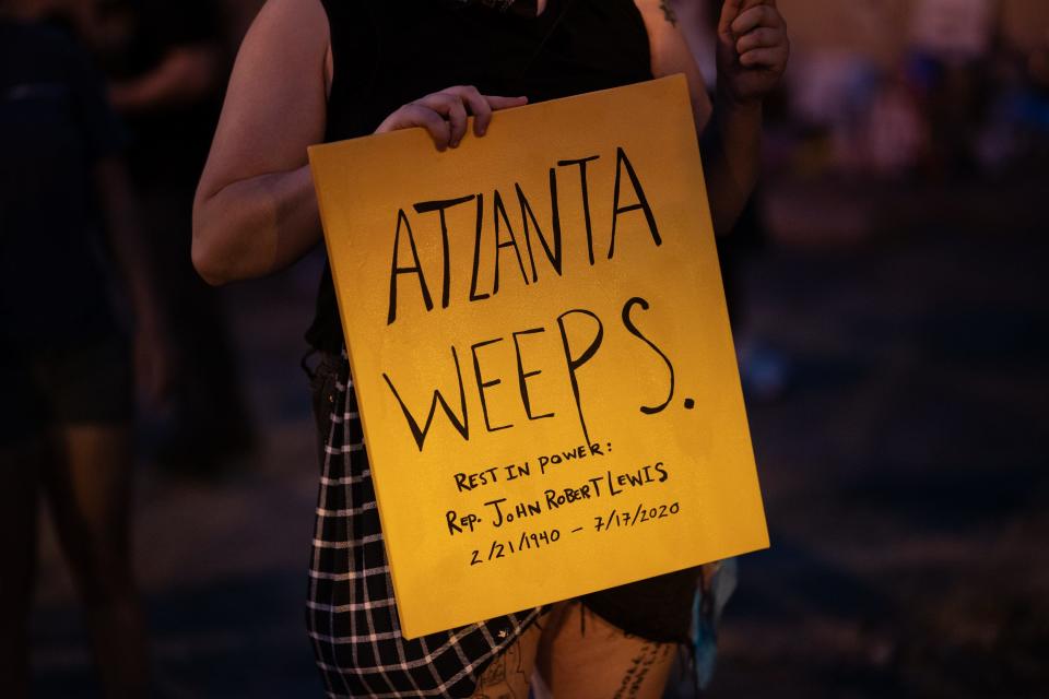 A woman holds a sign at a candlelight vigil for U.S. Rep John Lewis on July 19, 2020 in Atlanta, Georgia.