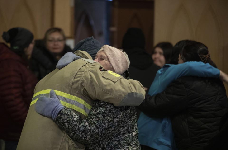 Community members embrace during a vigil for the six people killed in a plane crash, in Fort Smith, Northwest Territories, on Wednesday, Jan. 24, 2024. (Jason Franson/The Canadian Press via AP)