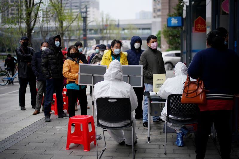 People wearing face masks line up outside a Hankou Bank branch in Wuhan