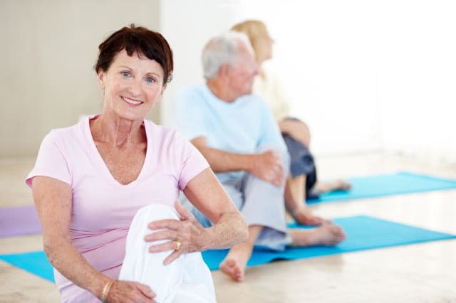 Portrait of a senior woman enjoying a yoga class with other seniors