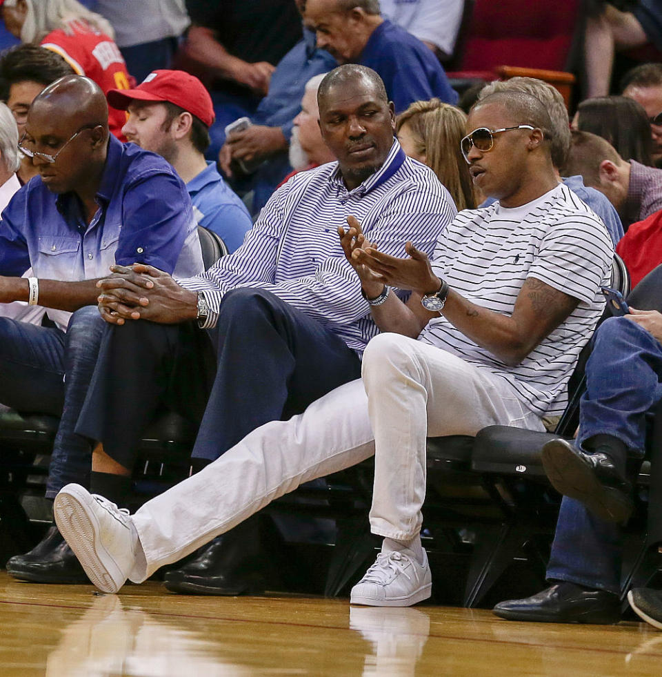 Steve Francis (right) speaks with fellow former Houston Rockets player Hakeem Olajuwon during a Rockets-Lakers game in Houston on April 10, 2016. (Getty Images)