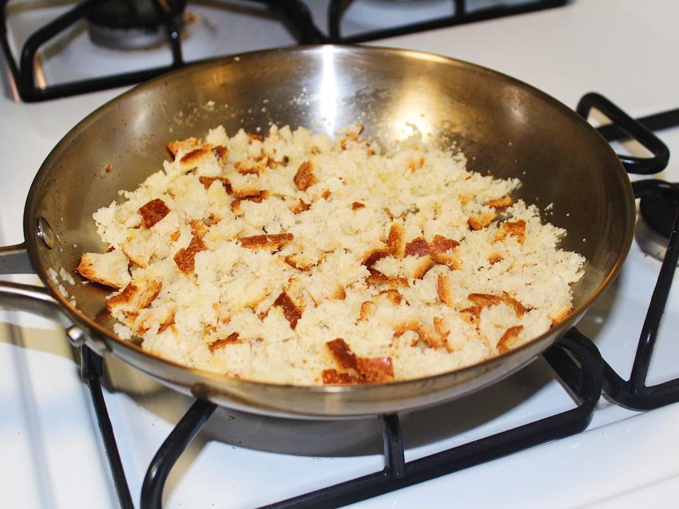 homemade breadcrumbs toasting in stainless steel pan