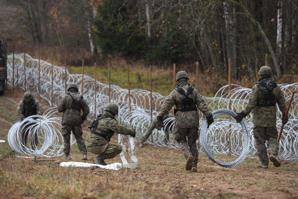 Polish soldiers begin laying a razor wire barrier along Poland’s border with the Russian exclave of Kaliningrad in Wisztyniec, Poland, on Wednesday Nov. 2, 2022. Poland’s government ordered the construction of the barrier after Russia’s aviation authority decided to launch flights from the Middle East and North Africa to Kaliningrad. The Polish government said it was acting to prevent a migration crisis at that border. (AP Photo/Michal Kosc)