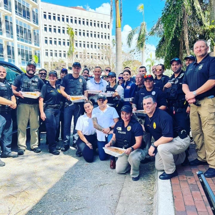 Genevieve and Cal Bruno, kneeling in white, pose with first responders outside of their restaurant, Bruno's of Brooklyn in downtown Fort Myers. The Brunos estimate they handed out more than 7,000 free meals in the week following Hurricane Ian.