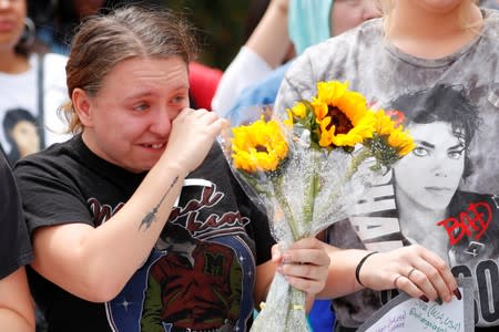 A fan wipes away tears after a moment of silence as people gather at Forest Lawn Cemetery ten years after the death of child star turned King of Pop, Michael Jackson, in Glendale, California,