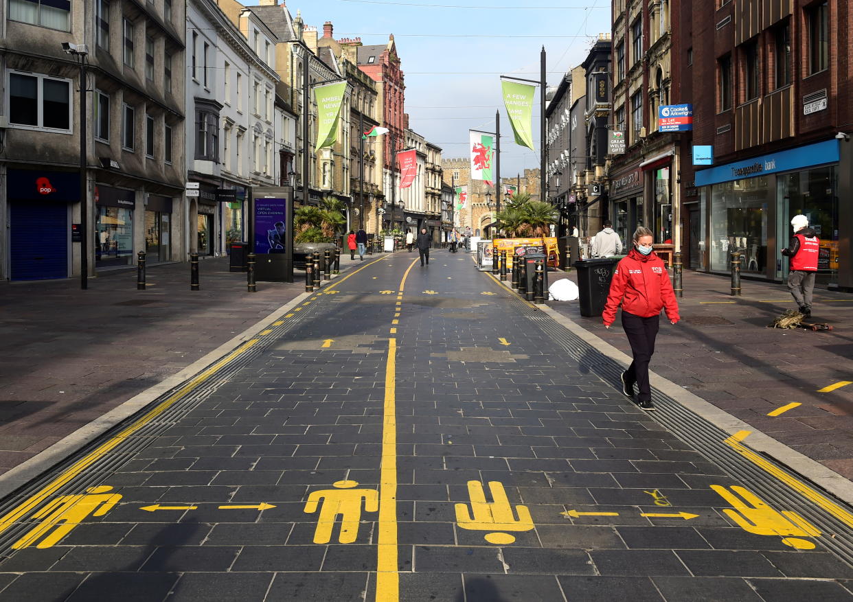 A person wears a face mask as they walk through the city centre as the coronavirus disease (COVID-19) outbreak continues in Cardiff, Wales, Britain October 19, 2020. REUTERS/Rebecca Naden