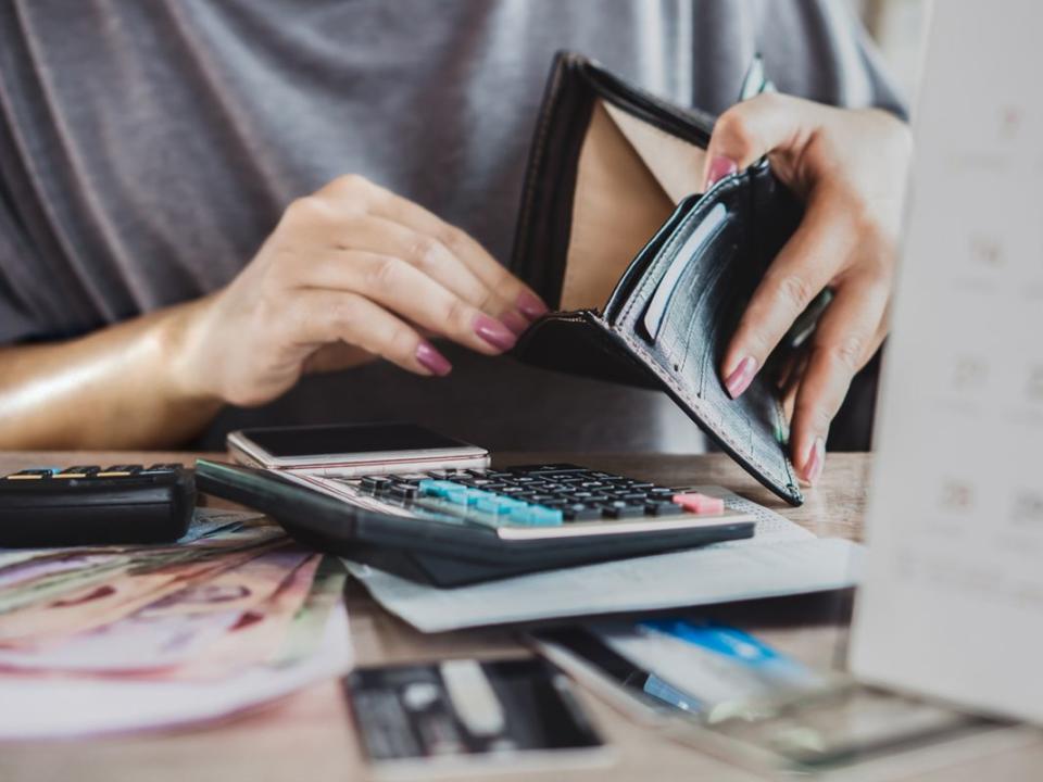 poor woman hand open empty purse looking for money for credit card debt