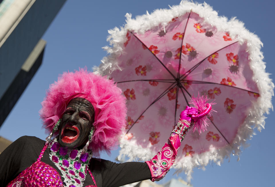 A reveler poses for photos during the annual Gay Pride Parade in Sao Paulo, Brazil, Sunday, May 4, 2014. Gay rights advocates are calling for a Brazilian law against discrimination as they gather by the hundreds of thousands in Sao Paulo for one of the world's largest gay pride parades. (AP Photo/Andre Penner)