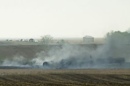Smoke from the wreckage of several oil tanker cars that derailed in a field near the town of Heimdal, North Dakota May 6, 2015. REUTERS/Andrew Cullenâ€¨