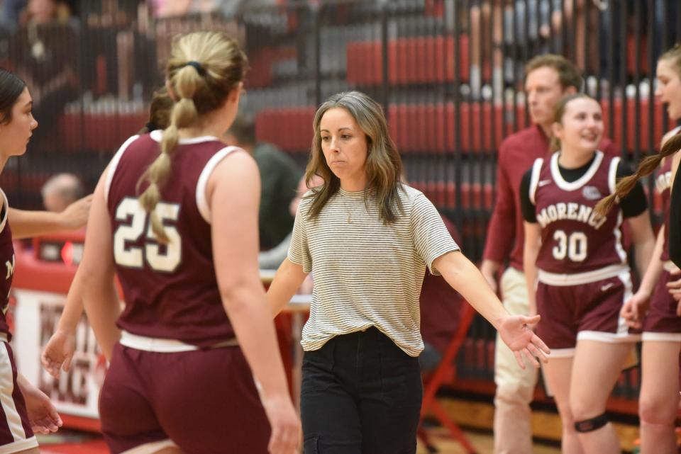 Morenci head coach Ashley Joughin greets her players after a timeout during the Division 4 regional final against Allen Park Inter-City Baptist at Whitmore Lake.