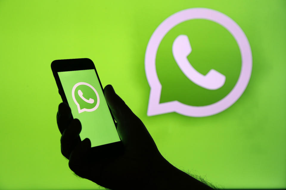 PARIS, FRANCE - DECEMBER 10: In this photo illustration, the WhatsApp logo is displayed on the screen of an iPhone in front of a TV screen displaying the WhatsApp logo on December 10, 2019 in Paris, France. The WhatsApp instant messenger service will stop working on millions of phones in the next couple of months as the company withdraws support for some older mobile platforms. From February 1, 2020, any iPhone running iOS 8 or older will no longer be supported, along with any Android device running version 2.3.7 or older. (Photo by Chesnot/Getty Images)