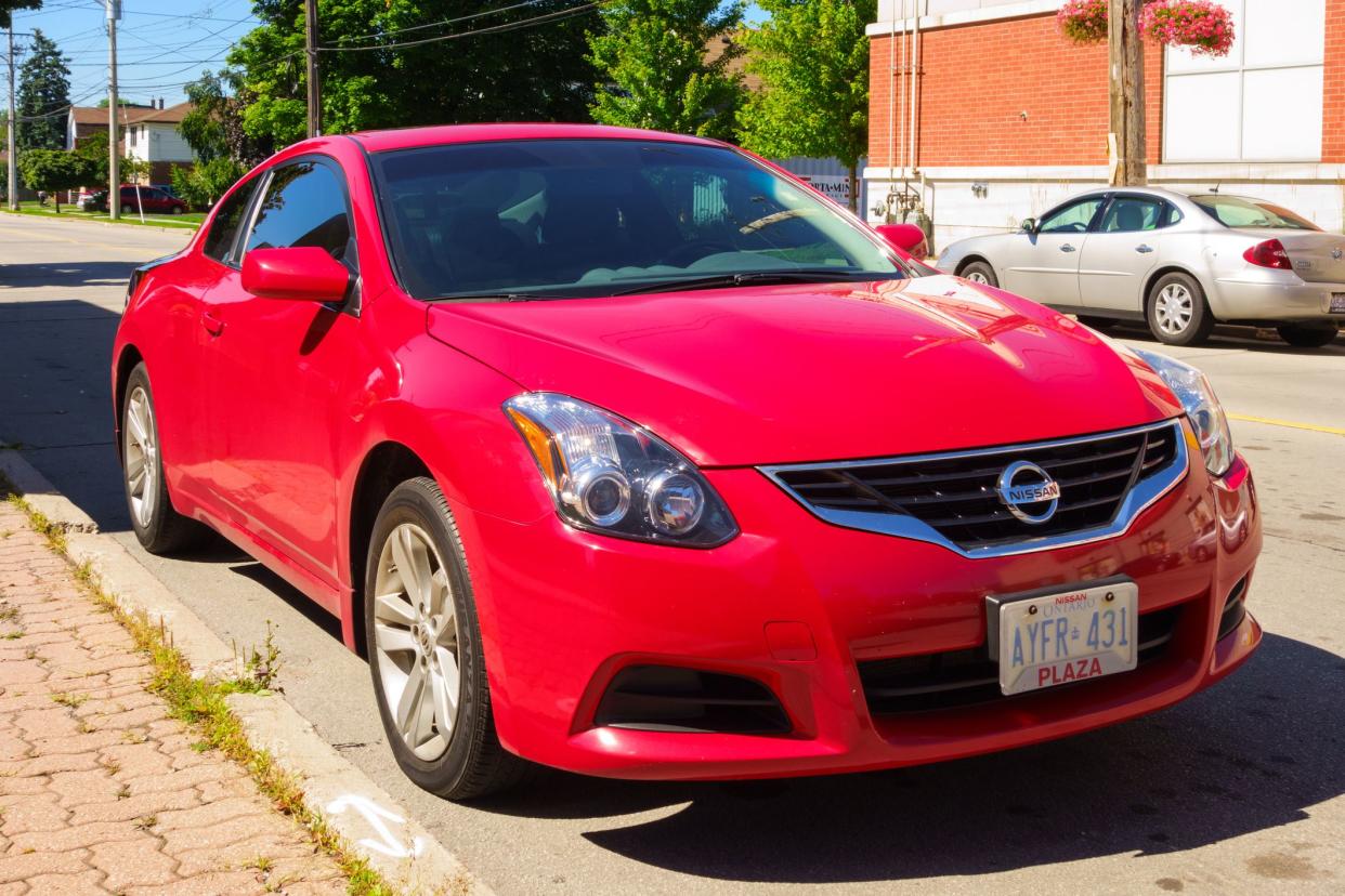 Hamilton, Canada - August 3, 2013: Red colored fourth generation Nissan Altima coupe parked on the street.