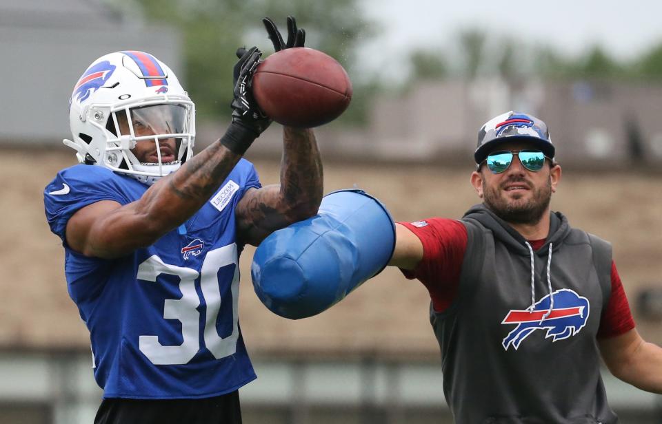 Bills cornerback Dane Jackson (30) eyes in the ball as he is hit by linebackers coach Bobby Babich during interception drills on day nine of Buffalo Bills training camp at St. John Fisher University in Rochester Thursday, Aug. 4, 2022. 